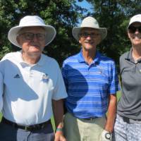 Four golfers on course one with a hat